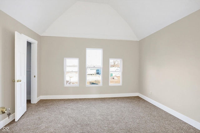 empty room featuring lofted ceiling and carpet flooring