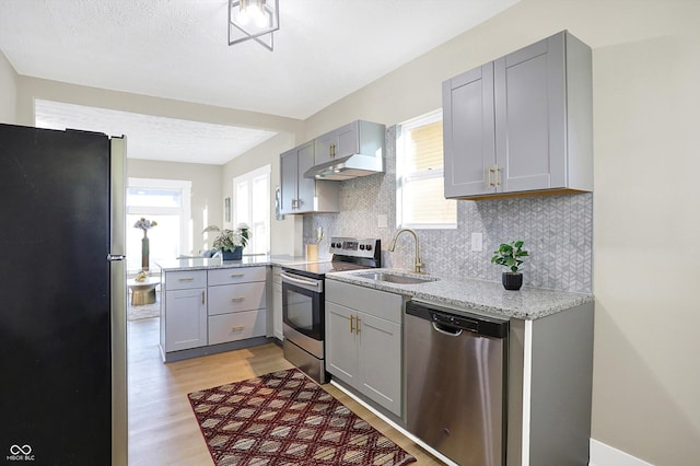 kitchen featuring plenty of natural light, appliances with stainless steel finishes, sink, and gray cabinetry