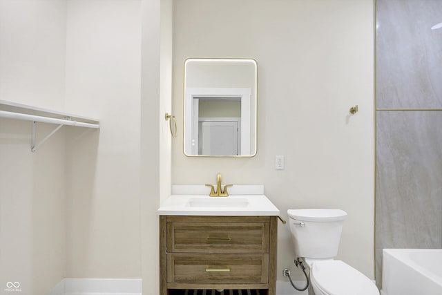 bathroom with vanity, a washtub, and toilet