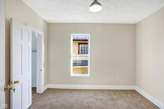 carpeted spare room featuring a textured ceiling