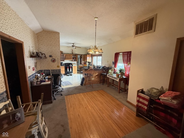 dining area with lofted ceiling, carpet, and a textured ceiling