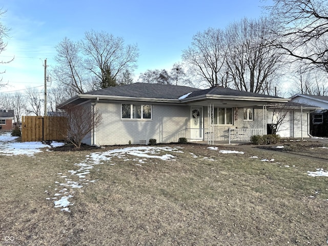 ranch-style home featuring a yard and covered porch