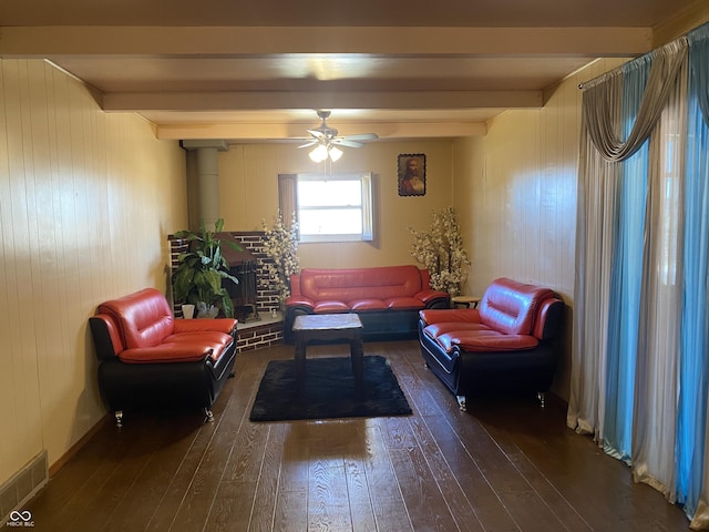 sitting room featuring beam ceiling, dark hardwood / wood-style floors, and ceiling fan