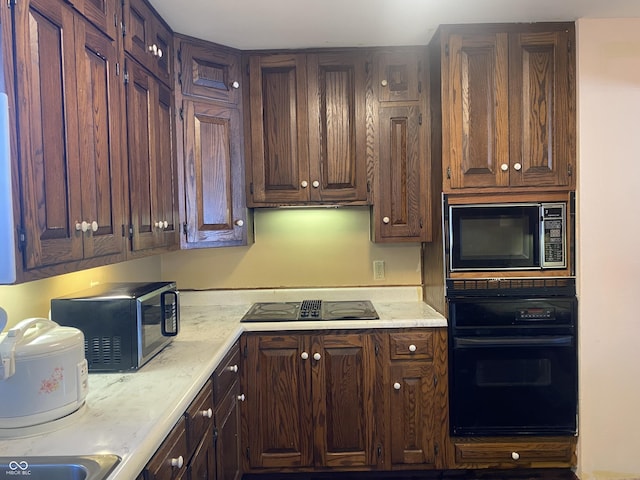 kitchen with dark brown cabinetry and black appliances