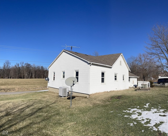 view of side of property featuring a yard and central air condition unit