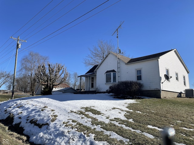 snow covered property with central AC unit