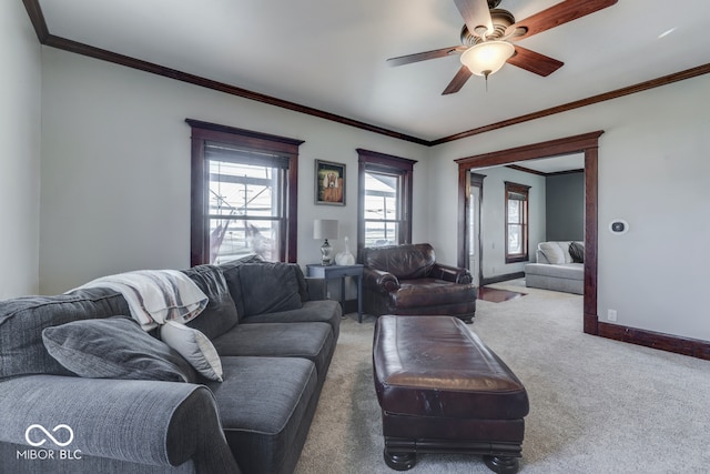 carpeted living room featuring ornamental molding and ceiling fan