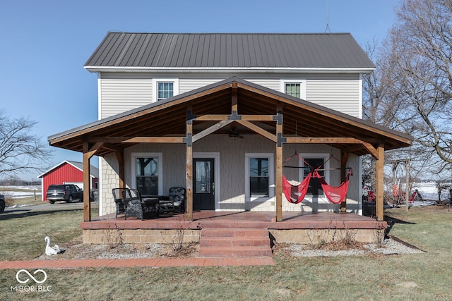 rear view of property with a lawn, ceiling fan, and a porch