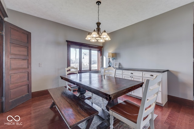 dining space featuring dark hardwood / wood-style flooring, a textured ceiling, and an inviting chandelier