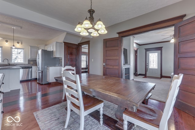 dining space with a wealth of natural light, sink, and dark wood-type flooring