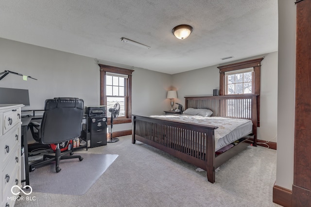 carpeted bedroom with multiple windows and a textured ceiling