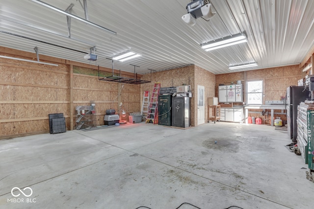 garage with a garage door opener and stainless steel fridge