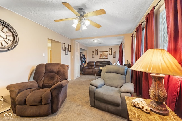 living room with ceiling fan, light carpet, and a textured ceiling