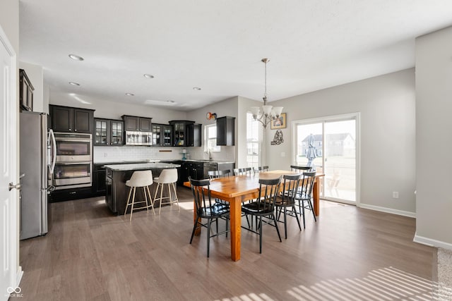 dining area with dark hardwood / wood-style flooring, a chandelier, and sink