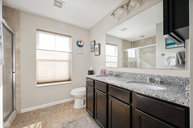 bathroom with vanity, toilet, and a shower with shower door