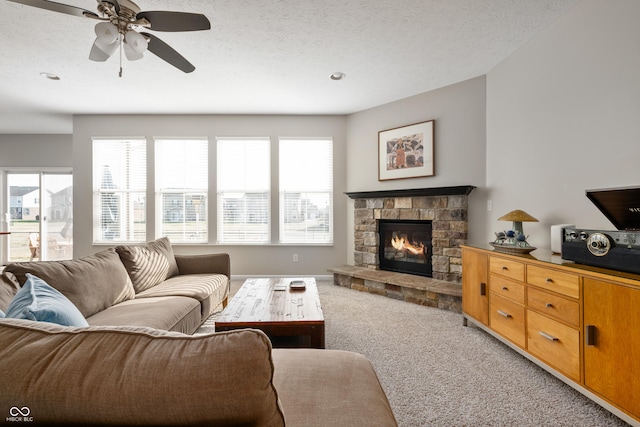 living room with light colored carpet, plenty of natural light, a fireplace, and a textured ceiling