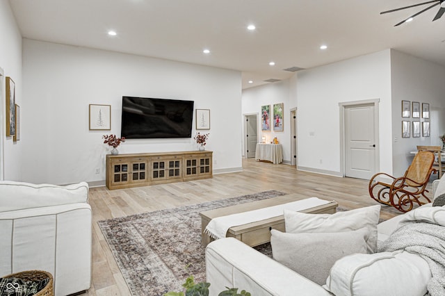 living room featuring ceiling fan and light hardwood / wood-style flooring