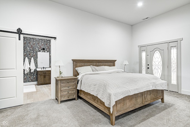 carpeted bedroom featuring access to outside and a barn door