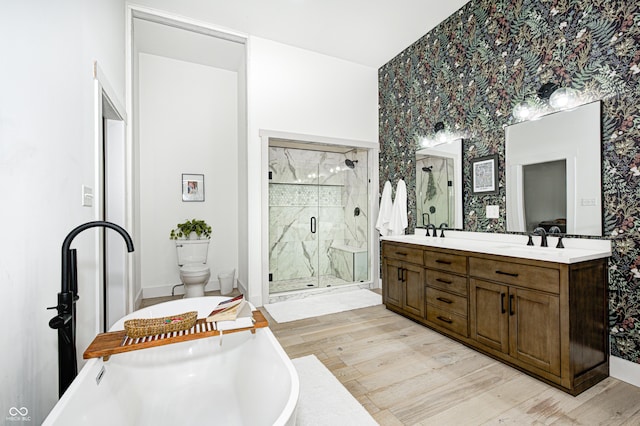 full bathroom featuring hardwood / wood-style flooring, vanity, separate shower and tub, and toilet