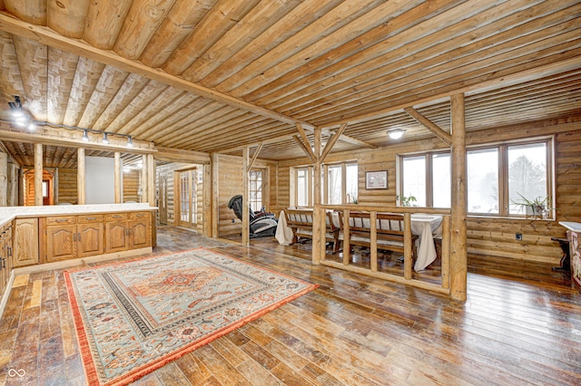 interior space with hardwood / wood-style flooring, a wealth of natural light, and rustic walls