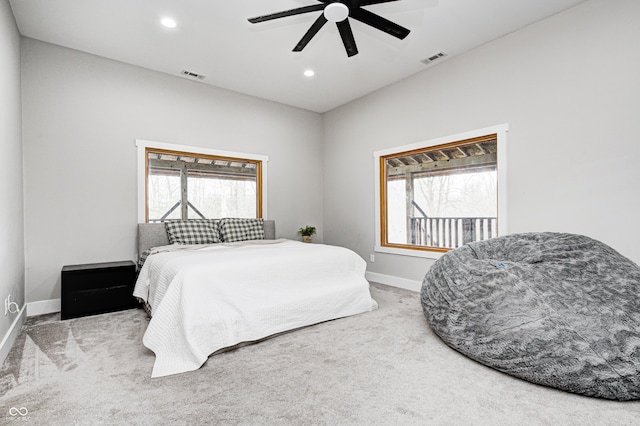 bedroom with multiple windows, light colored carpet, and ceiling fan