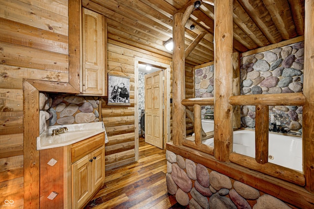 kitchen featuring sink, dark hardwood / wood-style floors, wooden ceiling, beamed ceiling, and light brown cabinets