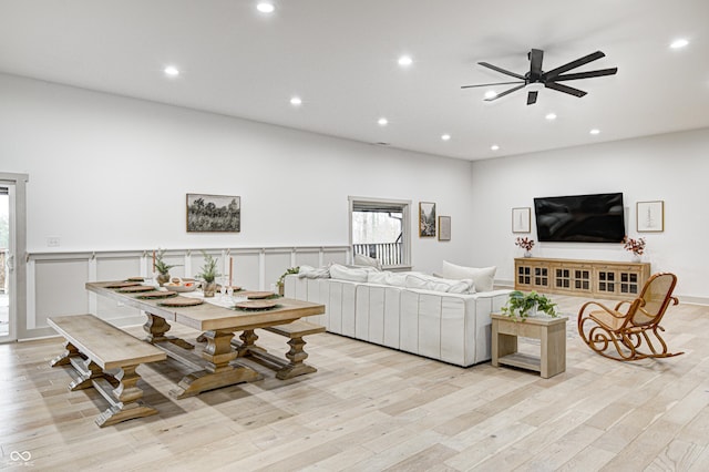 living room featuring ceiling fan and light hardwood / wood-style flooring