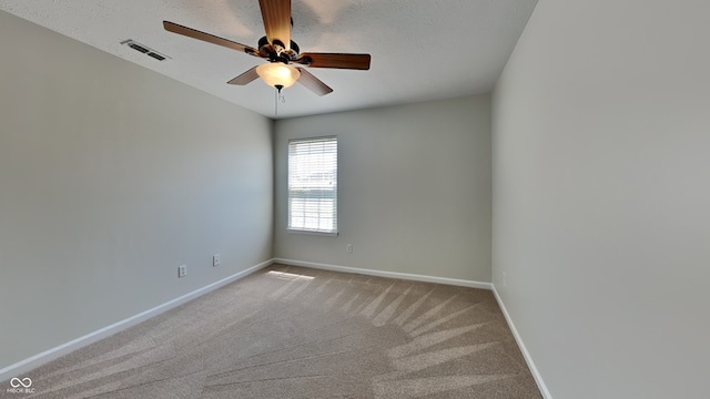 carpeted spare room with a textured ceiling and ceiling fan