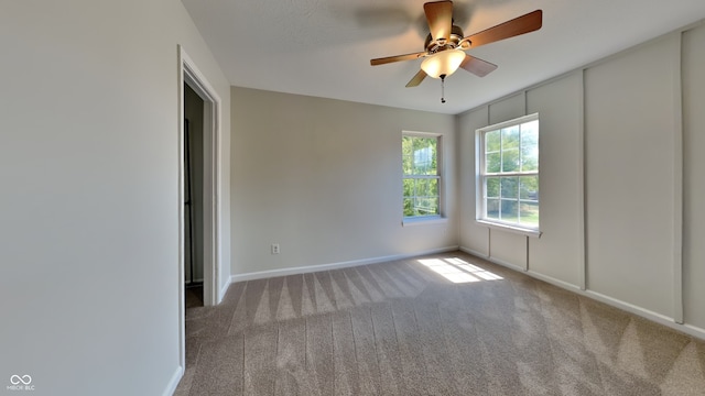 carpeted empty room featuring ceiling fan