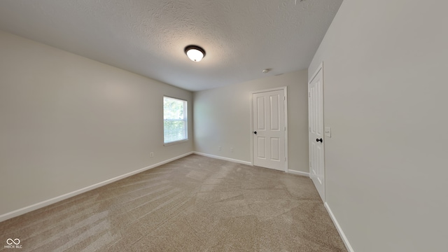 carpeted spare room with a textured ceiling