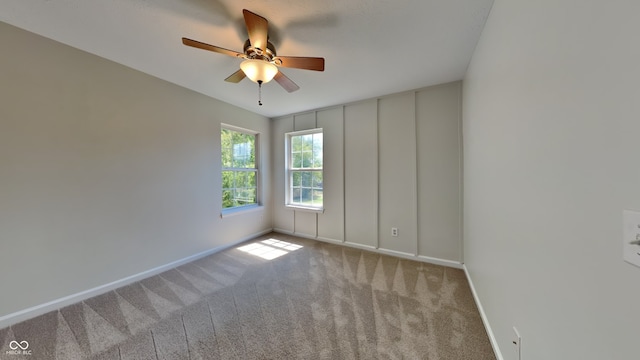 carpeted spare room featuring ceiling fan