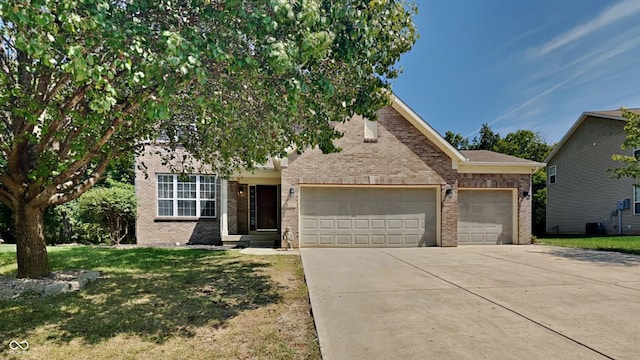 5131 Nicodemus Dr, Plainfield, IN 46168 - view of property hidden behind natural elements with concrete driveway, an attached garage, brick siding, and a front yard