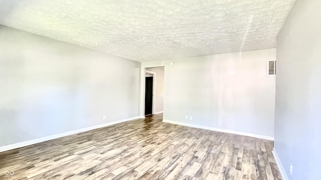 unfurnished room featuring a textured ceiling and light wood-type flooring