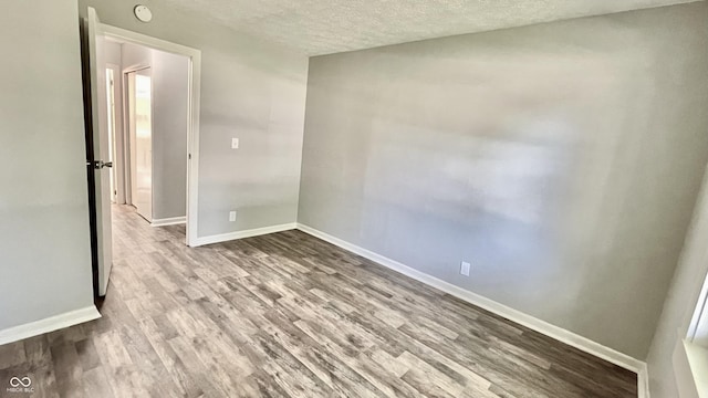 empty room featuring wood-type flooring and a textured ceiling