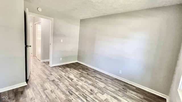 unfurnished room featuring a textured ceiling and light wood-type flooring