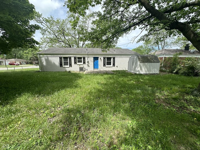 view of front of house featuring a front lawn and a storage unit