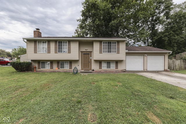 bi-level home with a garage and a front lawn