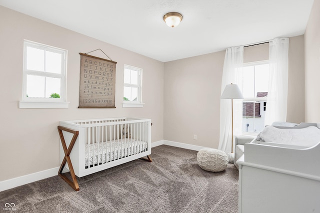 carpeted bedroom with multiple windows and a nursery area