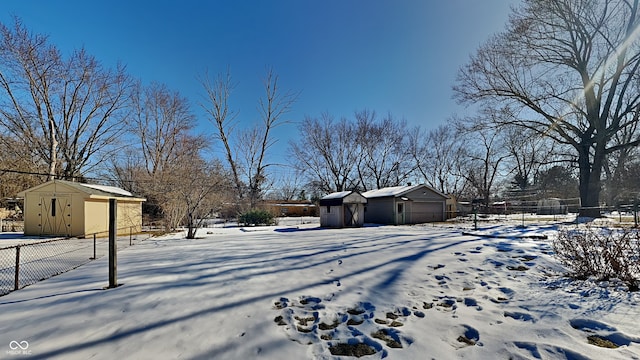 snowy yard featuring a storage shed