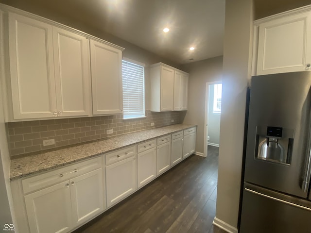 kitchen featuring white cabinetry, light stone counters, tasteful backsplash, and stainless steel refrigerator with ice dispenser