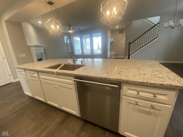 kitchen featuring white cabinetry, dishwasher, sink, and decorative light fixtures