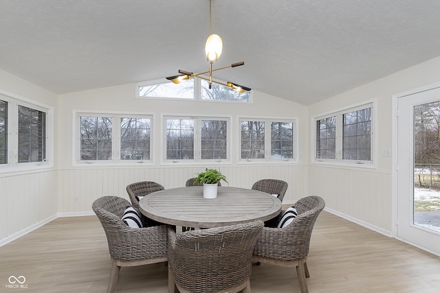 sunroom featuring vaulted ceiling, plenty of natural light, and a notable chandelier