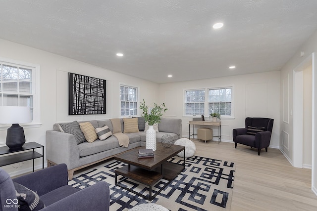 living room with light hardwood / wood-style floors and a textured ceiling