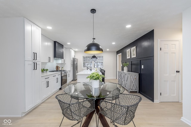 dining area featuring sink and light hardwood / wood-style flooring