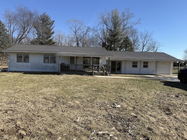 back of house with a garage, a yard, and covered porch