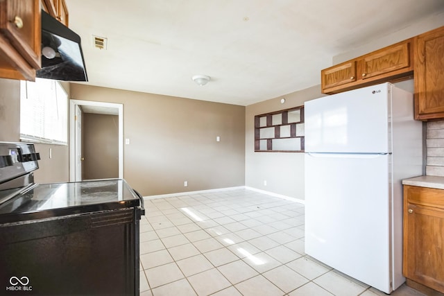 kitchen with white refrigerator, range with electric cooktop, tasteful backsplash, and light tile patterned floors