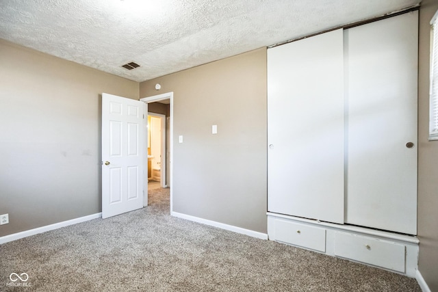 unfurnished bedroom with carpet flooring and a textured ceiling