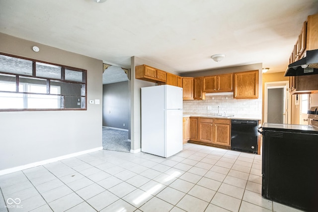 kitchen featuring dishwasher, sink, decorative backsplash, white refrigerator, and light tile patterned floors