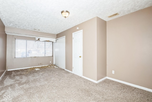 spare room featuring carpet and a textured ceiling