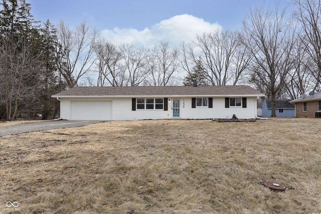 ranch-style home featuring a garage and a front yard